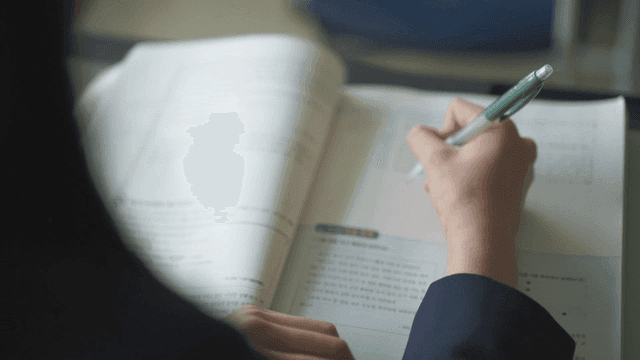 Student writing notes in a textbook