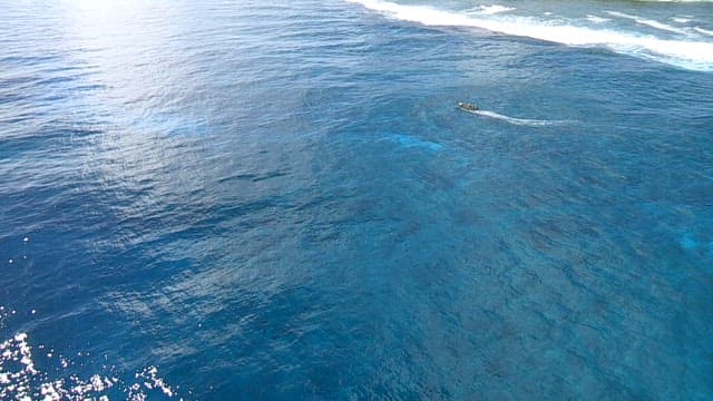 Small boat gliding across the blue ocean