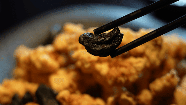 Chopsticks picking black garlic on tangsuyuk