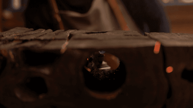 나무 조각의 구멍을 토치로 태우는 목공예가