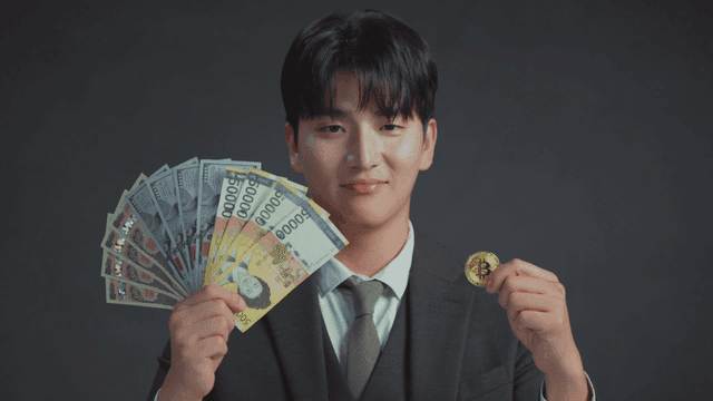 Man smiling at the Bitcoin in his hand