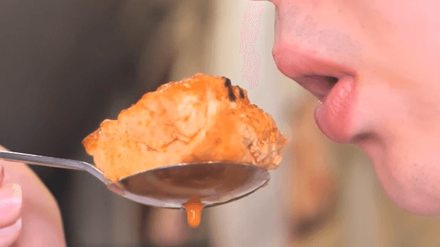 Person eating a spoonful of kimchi stew