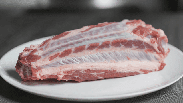 Raw pork ribs on a white plate