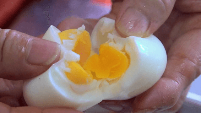 삶은 달걀을 반으로 쪼개는 손