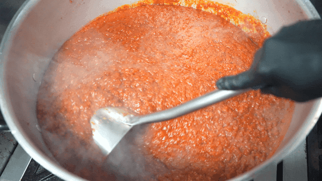 Red tomato sauce boiling in pot