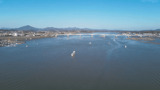 Wide river with boats and a bridge