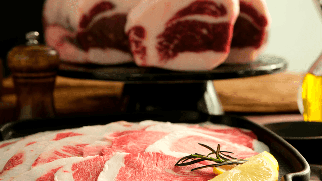 Slices of raw meat with lemon and rosemary