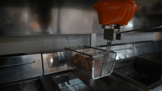 Frying machine cooking food in a kitchen