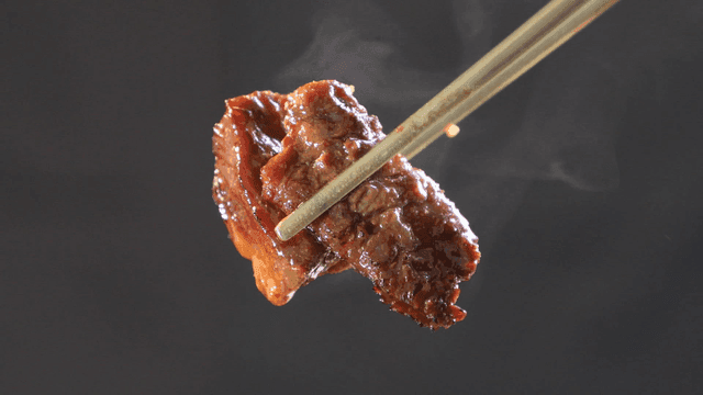 Grilled marinated meat picked up with chopsticks