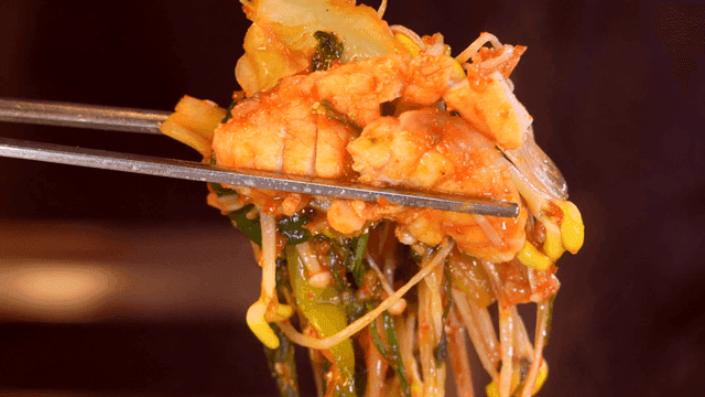 Chopsticks picking up pufferfish bulgogi stir-fried with vegetables
