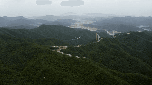 울창한 산악 지역 위의 풍력 터빈