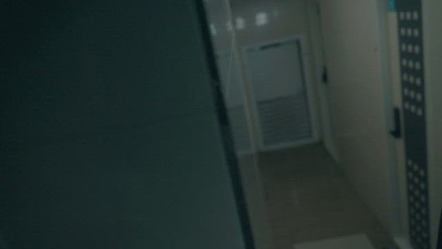 Man Walking Down a Dimly Lit Corridor