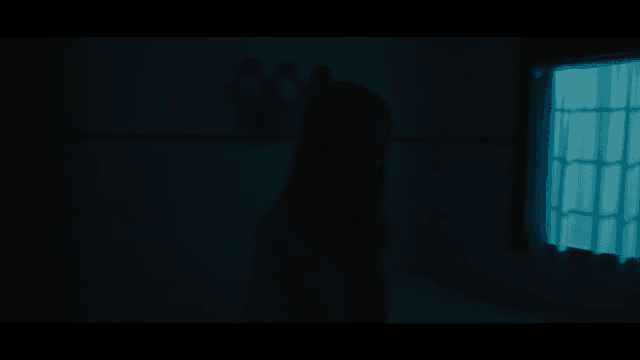 Woman turning on lamp in room