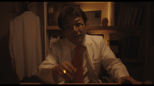 Doctor explaining while lowering glasses in dark office