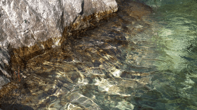 Clear stream flowing beside rocks