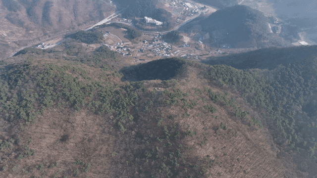 Forested mountain with small village