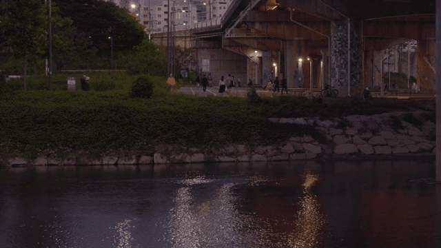 People walking along the riverside trail at sunset