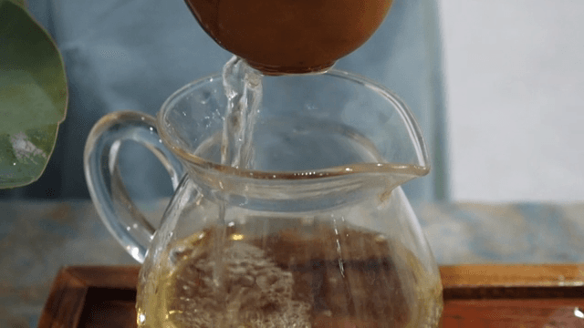 Pouring tea into a glass pitcher