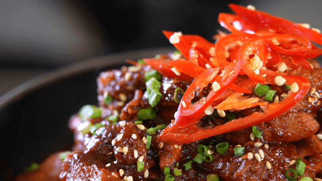 Spicy  braised short ribs garnished with peppers