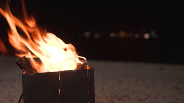 Flames dancing in a metal fire pit at night