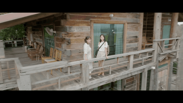 Two women standing on a wooden balcony