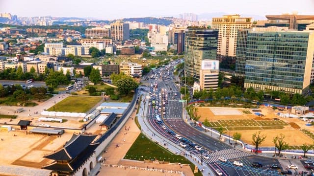 View of busy city street with skyscrapers and traffic throughout the day