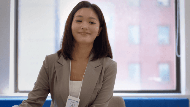 Female office worker carrying documents into office with window