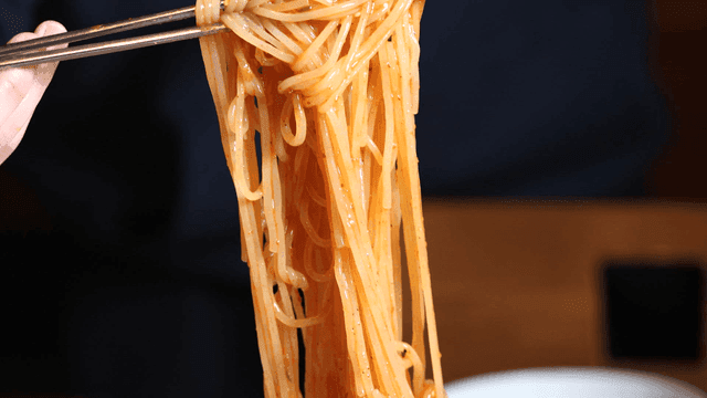 Sight of someone picking up spicy bibim guksu with chopsticks
