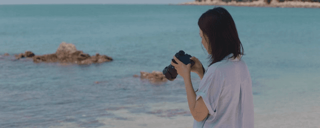 Woman taking photos by the seaside