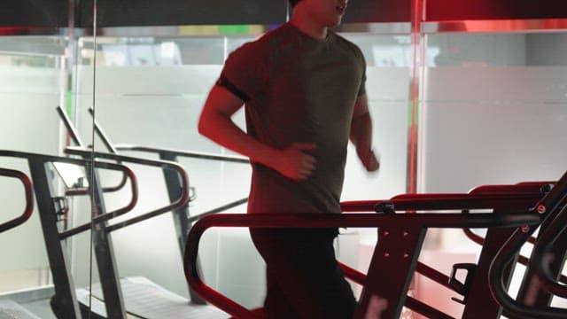 실내에서 러닝머신 위를 달리는 사람