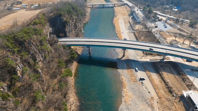 Bridge over a clear river with rocky cliffs