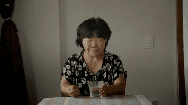 An elderly woman taking medicine