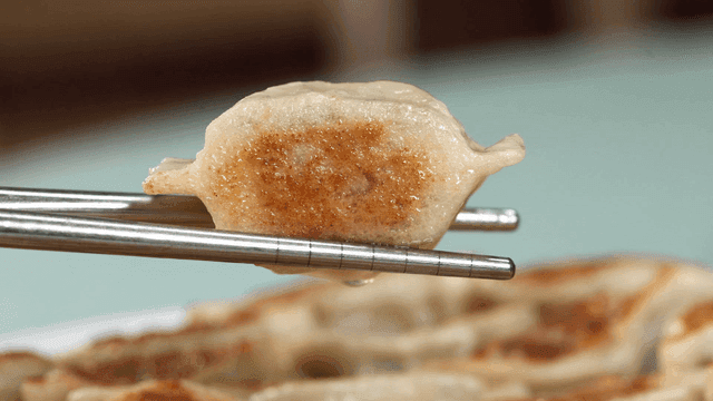Crispy fried dumplings picked up with chopsticks