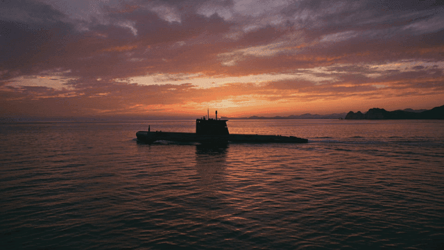 Submarine sailing at sunset
