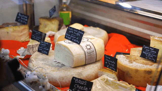 Various cheeses displayed in a market