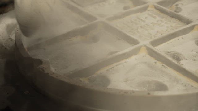 Worker applying powder to mold