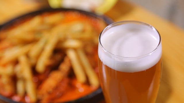 Glass of beer with fries and chicken