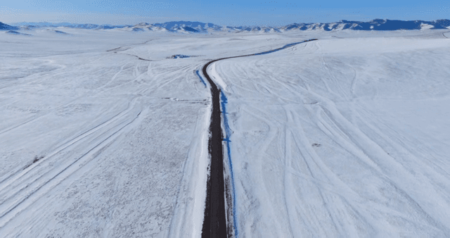 Long road through a snowy landscape