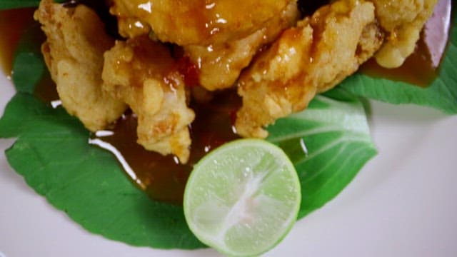 Delicious fried fish with thick sauce and lime