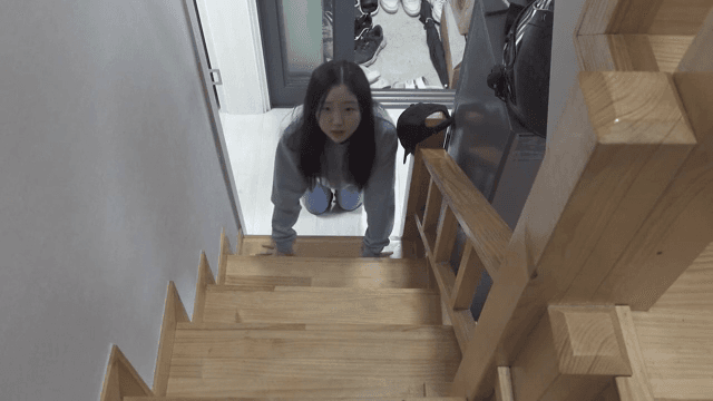 실내 계단을 힙겸게 기어 올라가는 여성