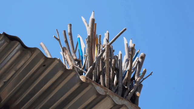지붕 위에 놓인 나뭇가지 연필 조각품