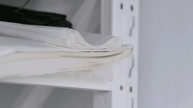 Folded fabrics on a white shelf