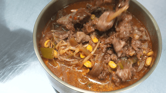 Bowl filled with meat poured with Korean beef soup