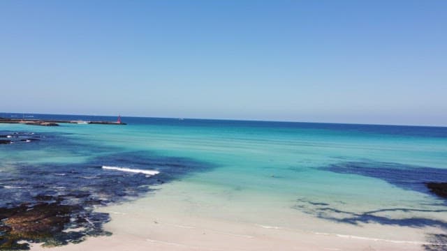 맑은 푸른 물이 있는 고요한 해변