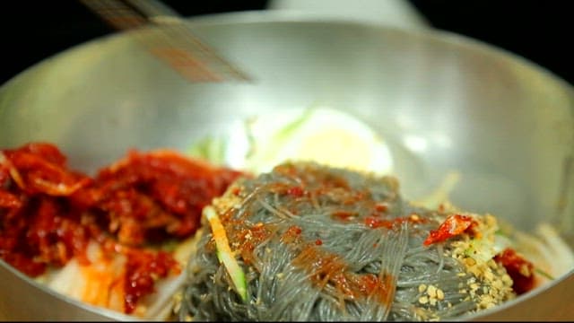 Cold buckwheat noodles with raw pollack picked up with chopsticks