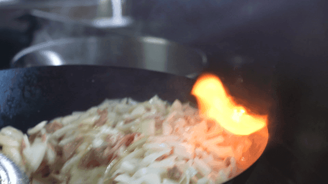 Onions and meat stir-frying in a wok