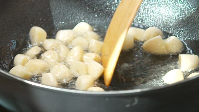 Garlic being sautéed in a pan