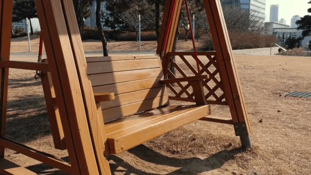 햇살 가득한 공원의 나무 그네