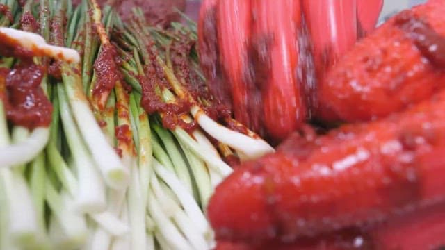 Making green onion kimchi by hand with rubber gloves