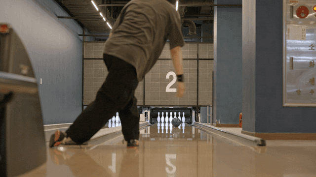 실내 볼링장에서 볼링을 치는 사람
